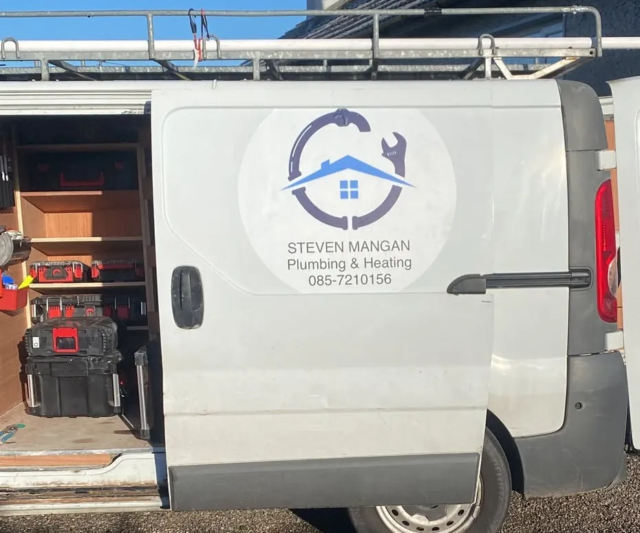 A Steven Mangan Plumbing & Heating van, the logo on the door and the side door open on shelving and tool cases